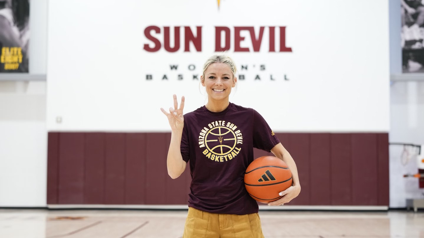 Molly Miller holding a basketball in an ASU basketball facility
